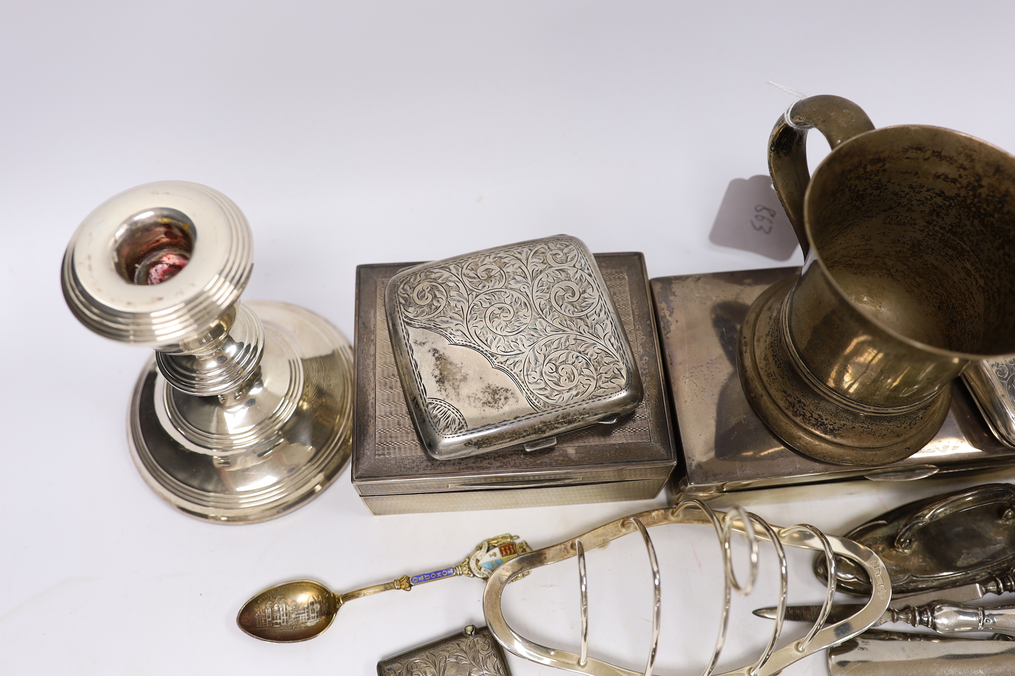 A George V silver christening mug by Charles Edwards, London, 1912, 86mm, together with two silver mounted cigarette boxes, two silver cigarette cases, a pair of silver mounted dwarf candlesticks, a silver vesta case, a